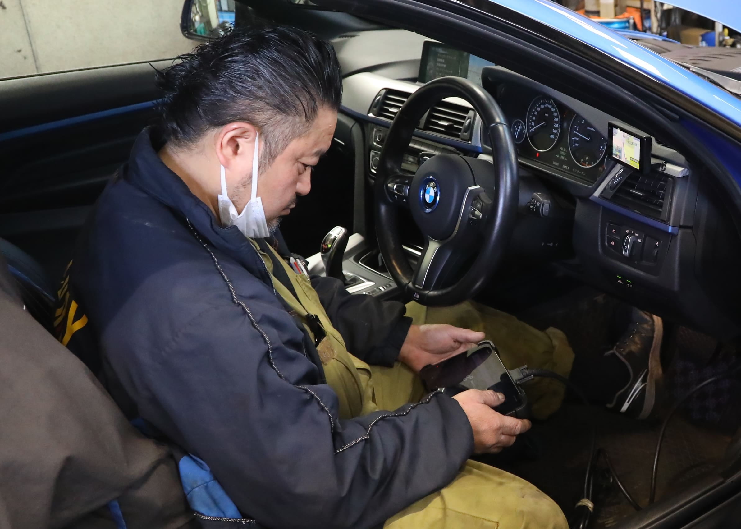 整備士が車の下に潜って点検している様子
